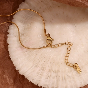 Detailed close-up of 18K gold plated stainless steel snake chain lobster clasp and extender