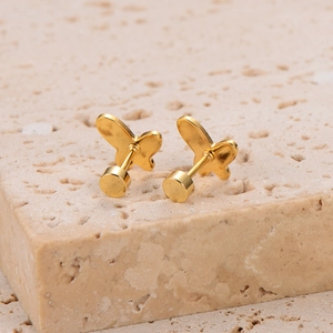 Elegant gold plated butterfly stud earrings with shell inlay on a natural stone base