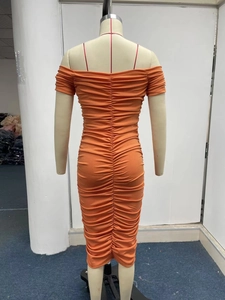 Detailed view of an orange off-shoulder ruched dress with slim-fit midi design