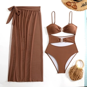 Detail van koffiebruine driedelige bikiniset met mesh rok en stervormige metalen ringen