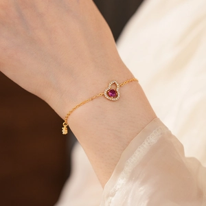Nahaufnahme des vergoldeten Wulu-Armbands mit weißen Zirkonia und rotem Mittelstein