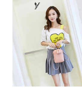 Mini pink crossbody bag for women shown as hand-carried and worn by a model in detail