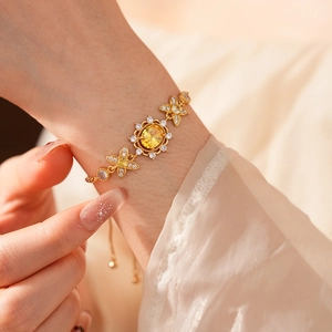 Detail eines Vintage-Goldarmbands mit gelbem Edelstein und funkelnden Blumenkristallen