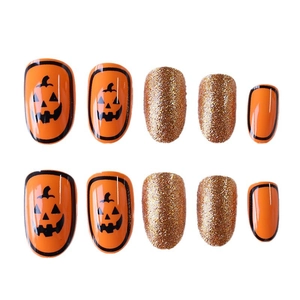 Halloween press-on nails with orange pumpkin smile designs and gold glitter short oval shape