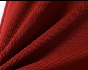 Close-up of breathable burgundy honeycomb knit fabric on men's long sleeve polo shirt