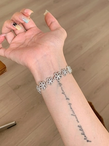 Macro detail of a silver flower bracelet with sparkling cubic zirconia on a woman's wrist