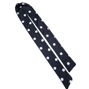 Gros plan détaillé d'une cravate noire à pois blancs avec une texture soyeuse