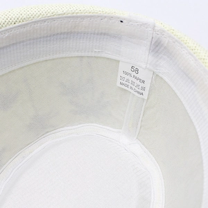 Detail view of woven sun hat showing size 58 label and 100% paper fiber material