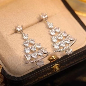Sparkling Christmas tree earrings with micro-set zircons on elegant beige velvet display