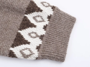 Close-up of brown and white geometric jacquard knit sweater with ribbed cuffs details