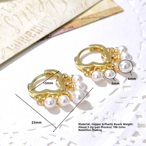 Detail view of 18k gold plated heart hoop earrings with pearl tassels on lace