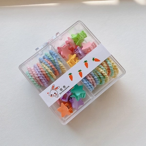 Close-up of colorful star hair clips and twisted elastic ties in a transparent box