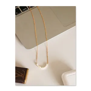 Elegant gold chain necklace featuring seven round white natural freshwater pearls
