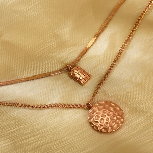 Double layer gold necklace with square and circular honeycomb textured pendants