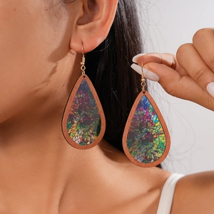 Close-up of bohemian wooden teardrop earrings with floral mosaic pattern on a model