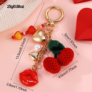 Detailed view of cherry and lip charm keychain with dimensions and gold heart engraving