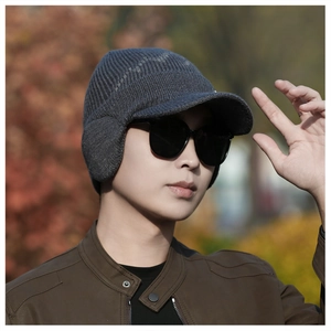 Detail of dark grey knit winter hat with earflaps and thick ribbed texture for men