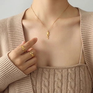 Elegant rose flower jewelry set with matte gold necklace and matching rings on a model