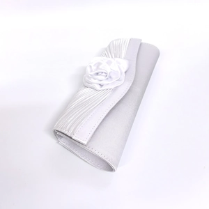 Close-up of elegant white satin evening clutch featuring a 3D rose flower decoration