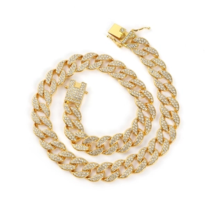 Iced out gold Cuban link necklace with sparkling crystals on white background