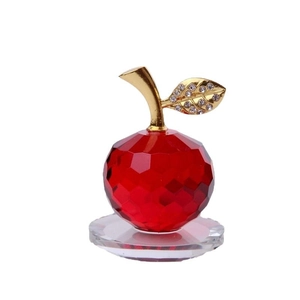Mela di cristallo rosso sfaccettato con foglia dorata e diamanti su base tonda