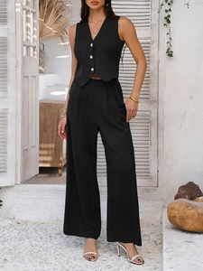 Detail view of black V-neck vest and wide-leg pants in textured fabric for women