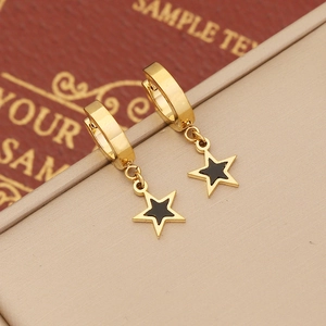 Gold hoop earrings with black star pendants displayed on a premium display stand