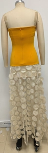 Detail view of mango yellow tube dress featuring 3D white polka dot applique on a tulle skirt