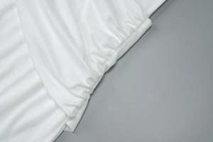Close-up detail of the elegant pleated design and soft white fabric on this slim-fit dress