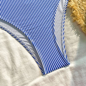 Detailed close-up of blue and white striped seersucker swimsuit fabric with soft inner lining
