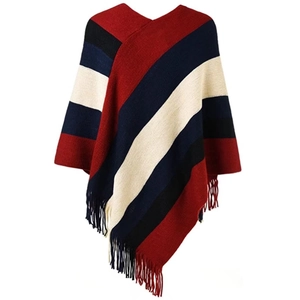 Close-up detail of knitted poncho featuring colorful stripes and fringe tassels decoration