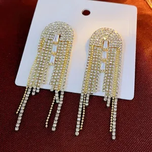 Elegant long silver needle tassel earrings with sparkling rhinestones in gold setting