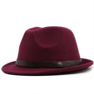 Λεπτομέρεια μπορντό καπέλου fedora με δερμάτινη ανάγλυφη κορδέλα και vintage έμβλημα