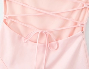 Detail of pink satin dress featuring cross-tie back design and invisible side zipper closure