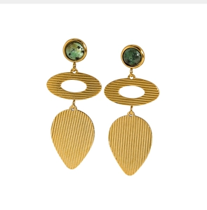 Détail de boucles d'oreilles dorées brossées avec pierre verte et pendentif en goutte