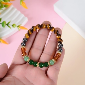 Bracelet élastique en œil de tigre et aventurine verte tenu à la main avec perles dorées