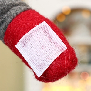 Detail of red and grey plush fabric with white hook and loop fastener for curtain tieback