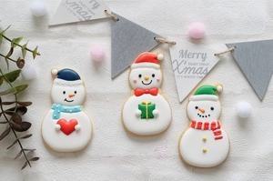 Detailed view of decorated Christmas snowman sugar cookies with hats and gift boxes