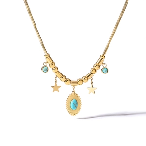 Detail of gold snake chain necklace with turquoise pendants and star charms