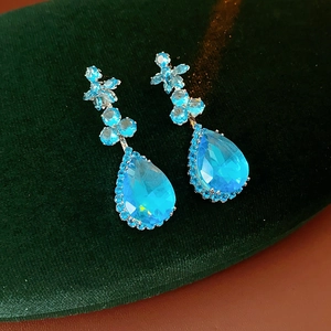 Macro d'oreilles en zircon bleu clair en forme de poire avec détails floraux