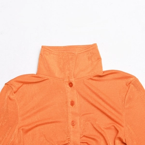 Close-up of orange textured fabric with three matching buttons on a chic collar top