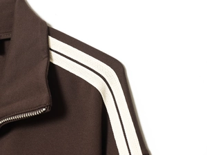 Close-up of brown striped sweatshirt featuring metal zipper and white shoulder stripes