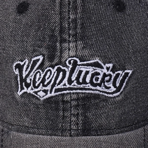 Detailed close-up of 3D letter embroidery and washed denim texture on baseball cap