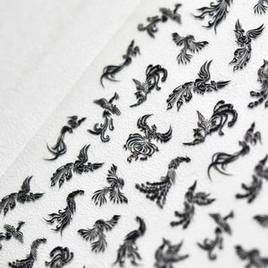 Macro shot of 5D embossed nail stickers featuring intricate black phoenix and bird patterns