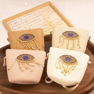 Detail of four colorful woven straw bags with diamond eye motifs on a wooden tray