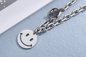 Detail of silver stainless steel thick chain necklace with smiley face and OT buckle