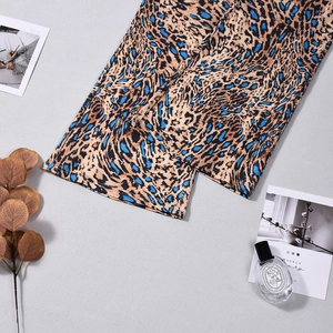Detail of leopard print trousers in electric blue and khaki with a silky texture finish
