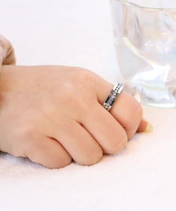 Silver stainless steel ring with cubic zirconia stones worn on a hand over white fur