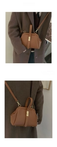 Detail of vintage brown leather handbag featuring gold metal clasp and doctor bag structure