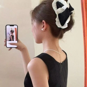 Elegant black and white plaid bow hair claw with acrylic pearls on a female model